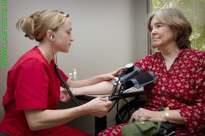 A healthcare practitioner checks a patient's blood pressure.
